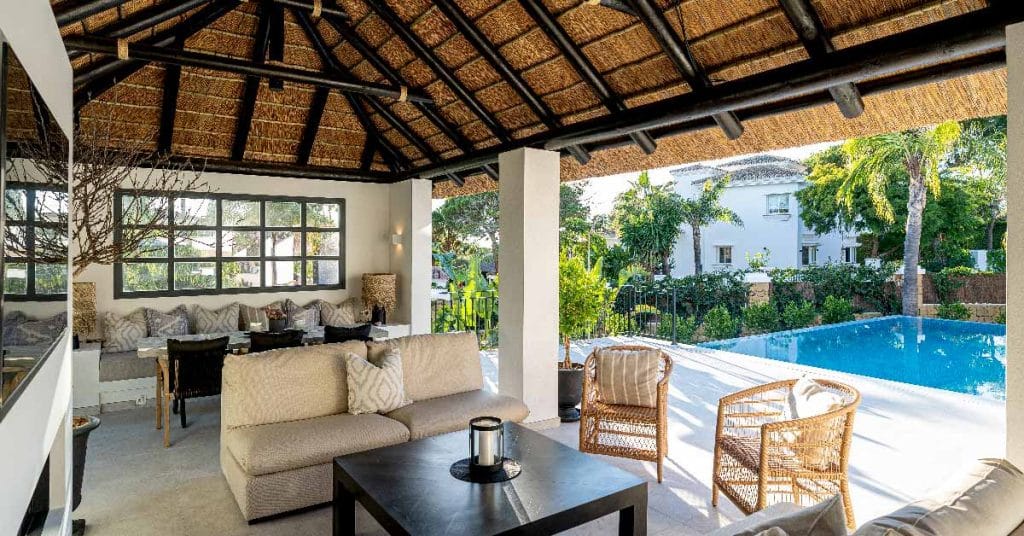 Outdoor kitchen with a built-in grill under a Cape Reed thatched roof in Elviria